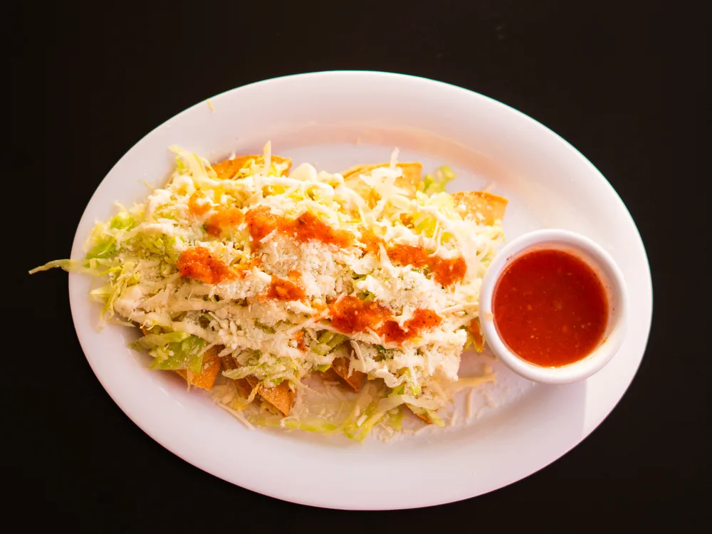 Tacos dorados crujientes con guarniciones